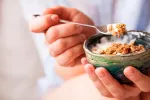 Tomar dos raciones de cereales integrales al día te ayuda a vivir más Persona tomando ración de cereales integrales al día