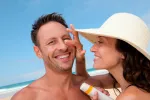 ¿Sabemos los españoles protegernos del sol? Pareja echándose crema solar