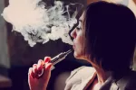 Persona fumando con un e-cigarrillo
