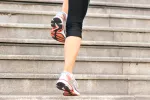Subir escaleras con energía varias veces al día protege el corazón Mujer subiendo las escaleras con energía