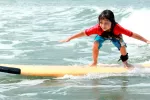 El surf podría ser una buena terapia para niños con autismo Niño con autismo practicando surf