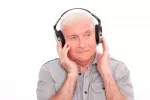 Un hombre mayor escucha música a través de auriculares