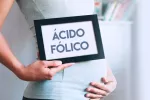 Mujer embarazada con un cartel de ácido fólico