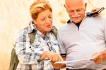 Viajes a precios reducidos para mayores de 60 años Una pareja de adultos mayores consulta una guía de viajes