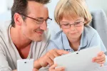 Padre e hijo mirando una tablet y smartphone