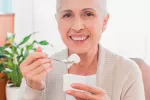 Mujer adulta tomando yogur para prevenir cataratas