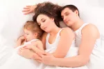 Dormir junto al bebé: el colecho, ¿sí o no? Padres practicando el colecho con su hijo