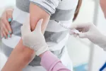 Rubéola Una profesional sanitaria administra una vacuna a una embarazada