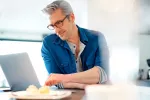 Claves para encontrar trabajo pasados los 50 años Hombre mira ofertas de trabajo en su portátil
