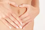 Qué es un legrado Mujer con sus manos sobre el vientre