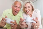 Videojuegos para mayores: descubre sus beneficios Pareja mayor jugando a un videojuego