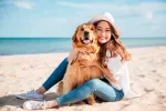 A la playa con tu perro Mujer en la playa con su perro