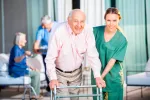 Residencias para la tercera edad Una cuidadora ayuda a un anciano en una residencia