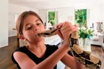 Serpientes en casa Niña jugando con una serpiente