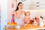Mujer lactante en la cocina con su bebé
