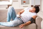 Hombre durmiendo la siesta y midiendo su presión arterial