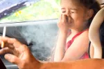 Hombre fumando en el coche