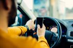 Padres millennials conduciendo y distraido por el móvil
