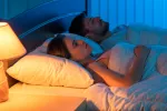 Dormir con luz artificial aumenta el riesgo de obesidad en las mujeres Pareja durmiendo con luz artificial