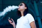 Mujer joven fumando un cigarrillo electrónico