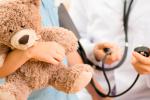 Niño con un oso de peluche visitando al médico