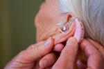 Mujer llevando audífono para reducir el riesgo de alzhéimer, depresión y caídas