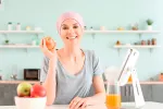 Nutrición y cáncer Mujer con problemas de cáncer en la cocina