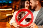 Símbolo de prohibición sobre unas copas de vino que bebe una pareja