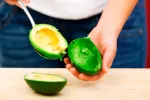 Mujer con un aguacate para prevenir la obesidad 