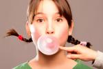 Chica masticando chicle para reducir el riesgo de caries