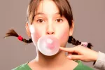 Chica masticando chicle para reducir el riesgo de caries