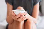 Beneficios del rusco para la salud y precauciones de uso Mujer tomando una infusión de rusco para combatir las varices