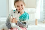 Crecer con un perro ayuda al desarrollo social y emocional del niño Niña con su mascota en casa