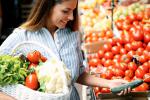 Mujer comprando frutas, verduras y alimentos integrales en el mercado