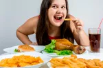 Una ingesta energética alta por la noche empeora la calidad de dieta Mujer joven cenando multitud de alimentos grasos