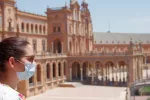 Turista con mascarilla en la Plaza de España de Sevilla