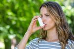 Mujer asmática usando su inhalador