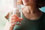 Mujer bebiendo agua por la mañana