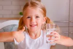 Niña pequeña aconsejando beber agua