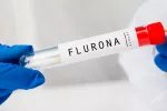 Médico con un tubo de muestra de sangre con resultado positivo para Flurona doble virus Gripe + coro