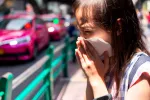 NIña respirando el aire contaminado de la ciudad