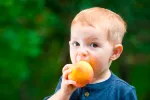 Niño con alergia comiendo un melocotón