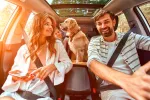 Familia viajando en el coche con su perro