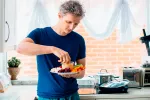 Hombre joven comiendo una ensalada mediterránea