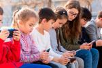 Grupo de niños y adolescentes usando el móvil
