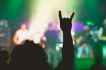Una persona realizando el gesto de los 'cuernos del diablo' en un concierto de heavy metal