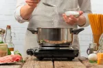 Cocinero añadiendo sal yodada al agua para cocer pasta