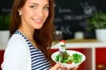 La dieta mediterránea reduce un 25% el riesgo cardiovascular en mujeres Mujer joven con un bol de ensalada
