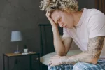 Cefalea en racimos mal tratada Hombre con cefalea en racimos doliéndose en su cama