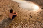 La crisis del agua pone en riesgo la salud de 190 millones de niños Niño sentado en tierra agrietada junto a una laguna seca